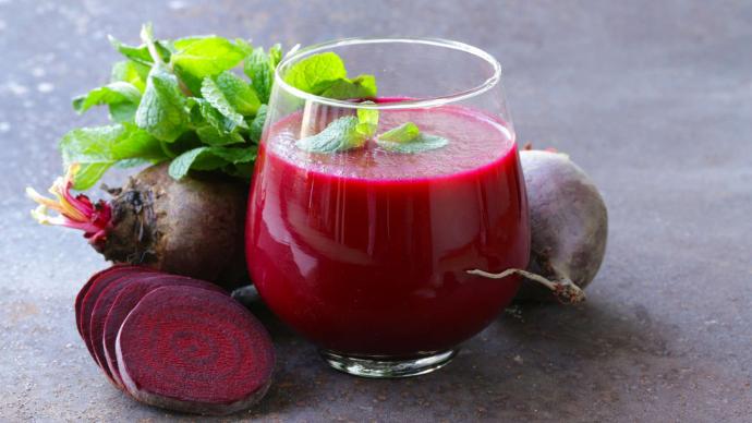 Betteraves entières, en lamelles et jus de betteraves dans un verre avec feuilles de menthe