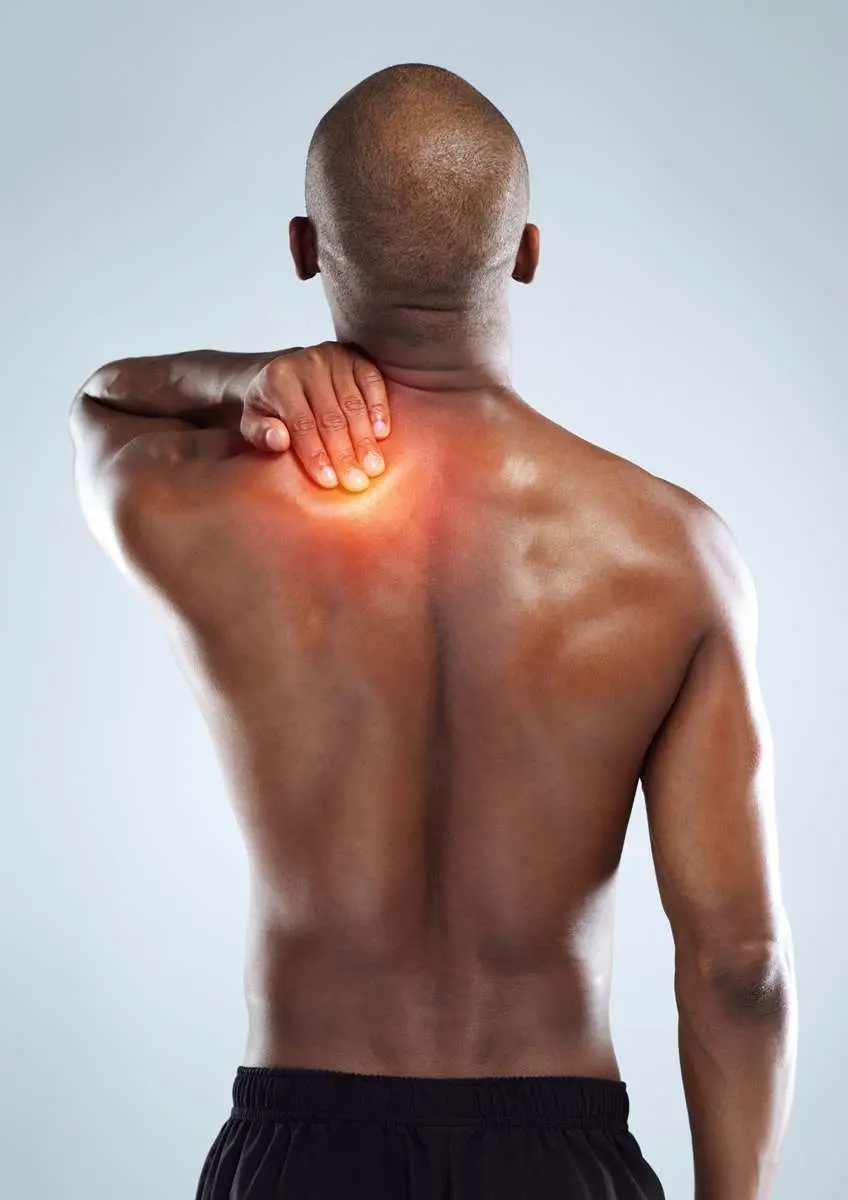 Homme noir de dos, dos nus avec unemain sur l'épaule gauche rouge