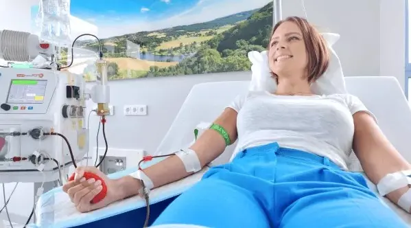 Séance de toxophérèse avec jeune femme en tee-shirt blanc et pantalon bleu qui sourit
