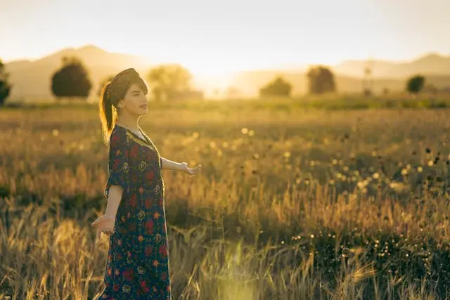 Femme dans champ coucher de soleil