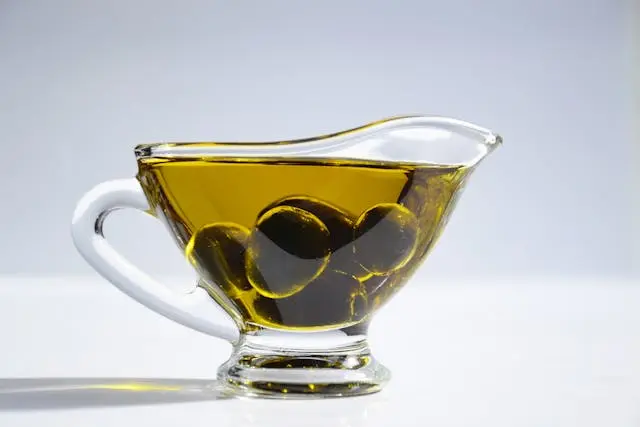 Huile d'olive avec olives dans tasse transparente avec anse