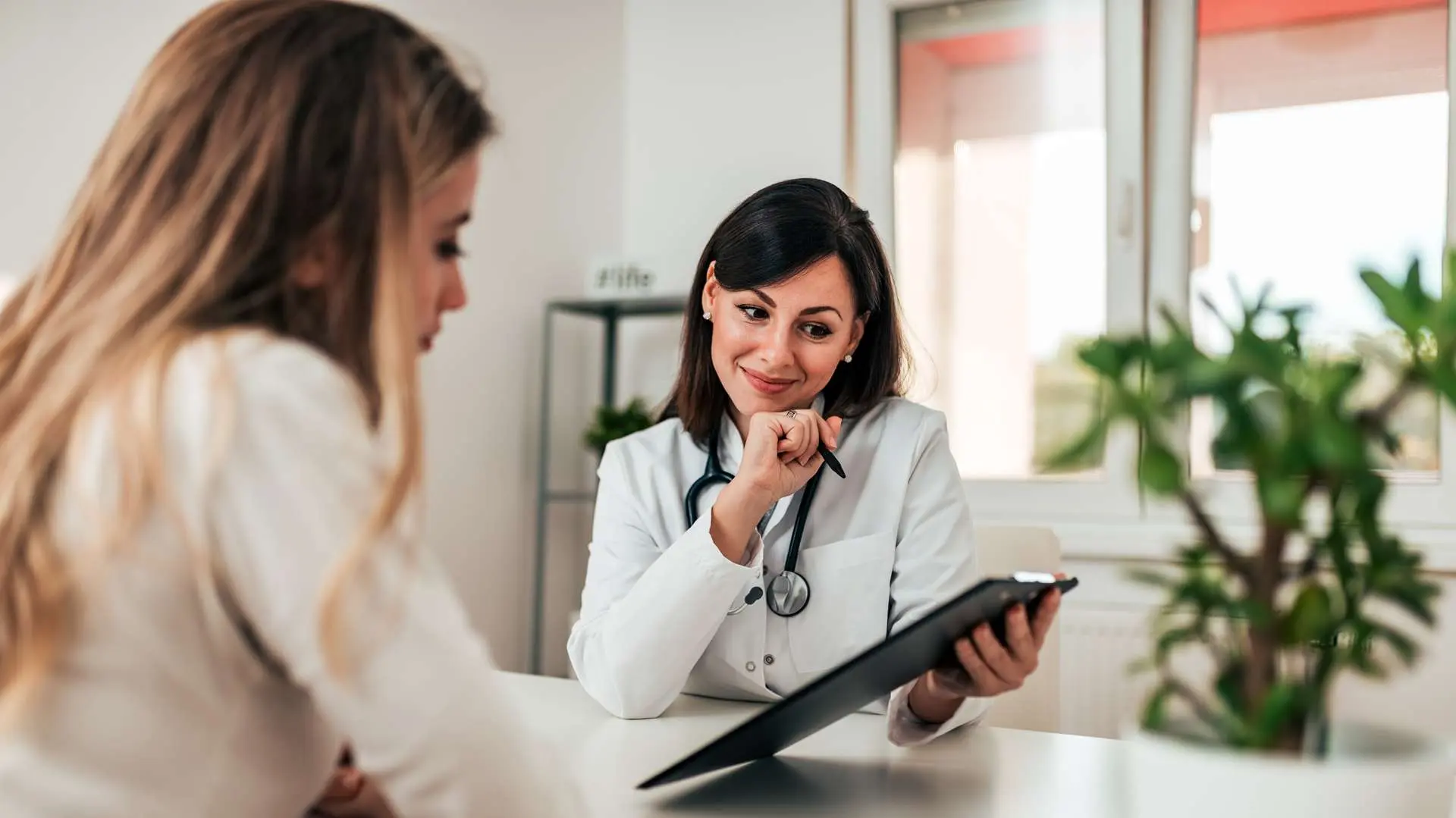 Consultation femme médecin et patiente avec plante verte derrière